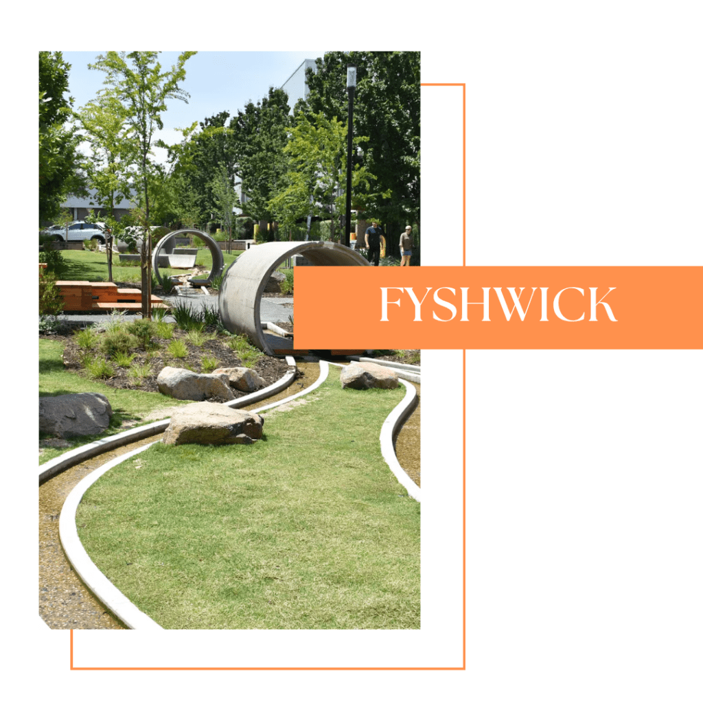 A landscaped park in Fyshwick featuring concrete tunnels, grassy areas, and natural stones, with people exploring the space.